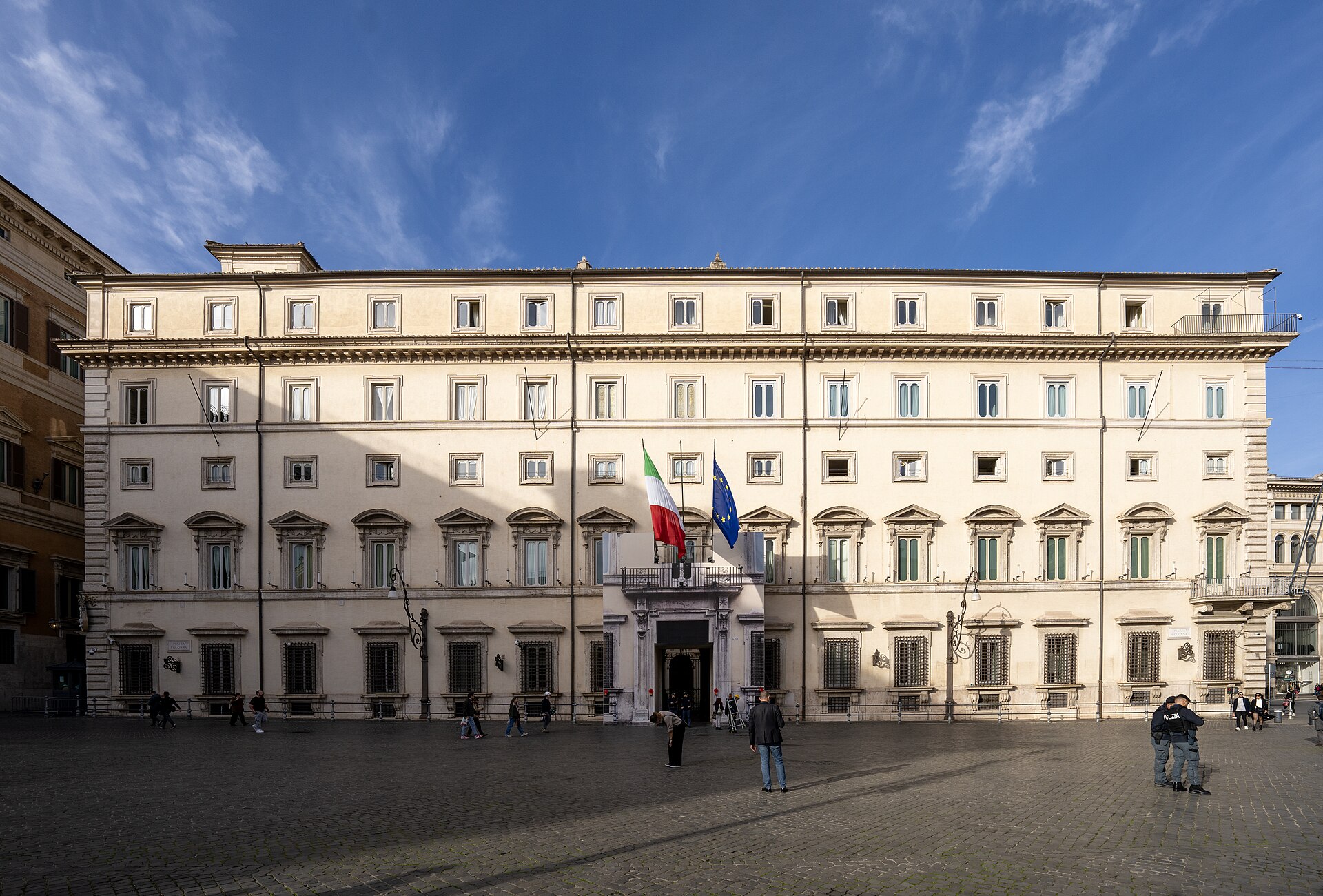 Facade of Palazzo Chigi in Rome, with the Italian Tricolour and the EU flag flanking the entrance.